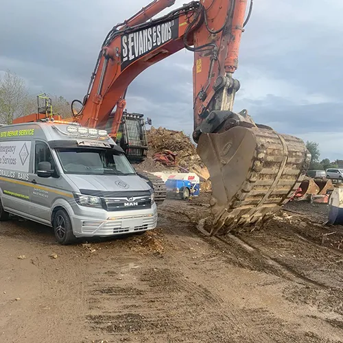 A van is parked next to a construction vehicle.