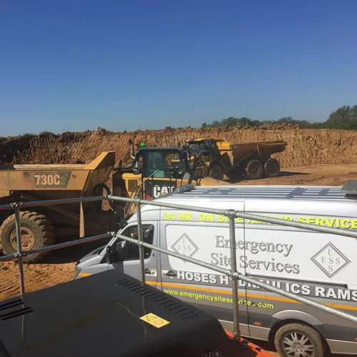 a couple of trucks parked next to each other on a dirt field